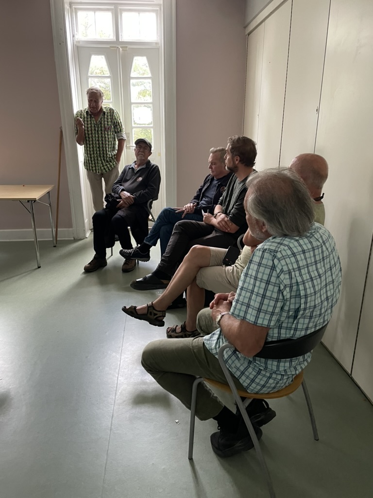 Niels Bang Andersen taler til siddende gæster ved døren